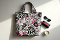Handmade quilted floral tote bag flatlay with mini boxy bag and accessories on white surface